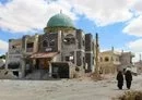 
Women walk past a damaged mosque in Daraa's Daraa al-Balad district on September 11, 2021. [Sam Hariri/AFP]        