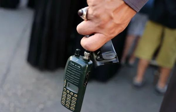 A man holds a radio (walkie-talkie) after removing the battery during a September 18 funeral in Beirut's southern suburb for the victims of a simultaneous pager explosion that targeted Hizbullah elements the previous day. [Anwar Amro/AFP]