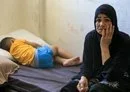 
A child sleeps on a bed next to a relative on September 24, at a Beirut school that has been turned into a temporary shelter for families displaced by conflict from southern Lebanon. [AFP]        