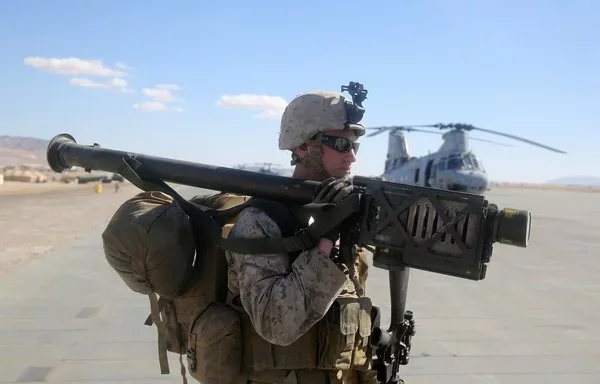 A US Marine carries a stinger weapon system before loading onto a CH-46 Sea Knight helicopter at Marine Corps Air Ground Combat Center Twentynine Palms, California, on February 3, 2014. [US Marine Corps]