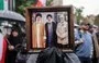 
A demonstrator in Tehran holds a photo of Iranian leader Ali Khamenei, late Hizbullah leader Hassan Nasrallah, and late IRGC Quds Force commander Qassem Soleimani, on September 28. [Atta Kenare/AFP]        