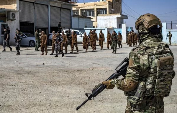 Syrian Kurdish security forces stand by as former detainees suspected of being ISIS members are released in Syria's northeastern city of Hasakeh on September 2. [Delil Souleiman/AFP]