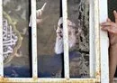 
A person opens a door adorned with a portrait of slain Hizbullah chief Hassan Nasrallah in al-Harjalah, south of Damascus, on October 15. [Louai Beshara/AFP]        