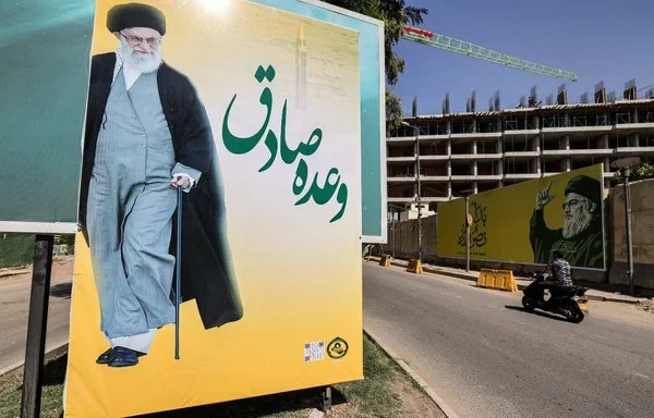 Billboards in Baghdad show Iran's leader Ali Khamenei and slain Hizbullah leader Hassan Nasrallah on October 7. [Ahmad al-Rubaye/AFP]