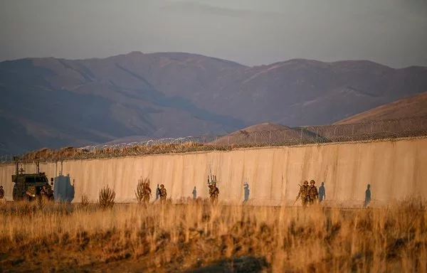 Turkish soldiers patrol near the border wall between Türkiye and Iran in Türkiye's Van province on November 1. [Ozan Kose/AFP]