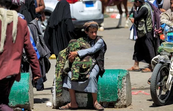 A street vendor in Sanaa displays camouflage-patterned fatigues for sale on March 24, 2022. [Mohammed Huwais/AFP]