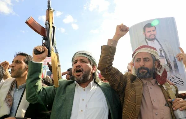 Yemeni men display weapons and portraits of Houthi leader Abdul Malik al-Houthi during a demonstration in Sanaa on January 5, 2024. [Mohammed Huwais/AFP]