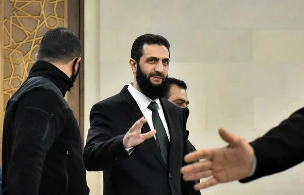 Syria's de facto leader Ahmed al-Sharaa, seen here in Damascus on December 22, 2024, adopts a statesmanlike pose in Western-style dress, underscoring his efforts to distance himself from al-Qaeda. [AFP]