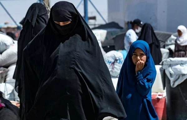 A woman and child walk in al-Hol camp in Syria's al-Hasakeh province on July 28, 2024. [Delil Souleiman/AFP]