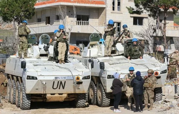 Residents of the southern Lebanese village of Yaroun talk to soldiers of the Lebanese army and UNIFIL at the entrance of their town on January 28. [Mahmoud Zayyat/ AFP]