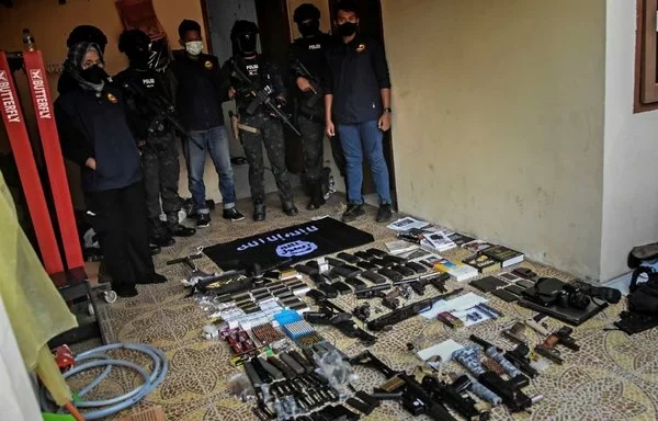 An Indonesian anti-terror unit displays items seized from an ISIS sympathizer arrested in Bekasi, near Jakarta, on August 14, 2023 for spreading terrorist propaganda on social media. [Rezas and Rezas/AFP]